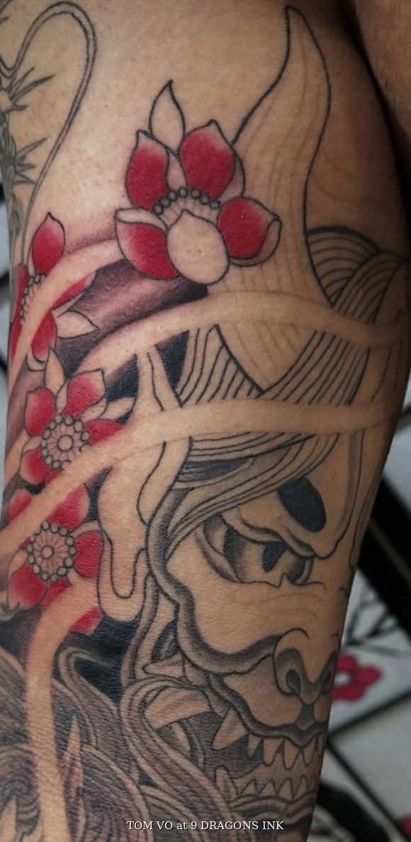 Tengu mask tattoo with florals by Tom Vo in San Jose