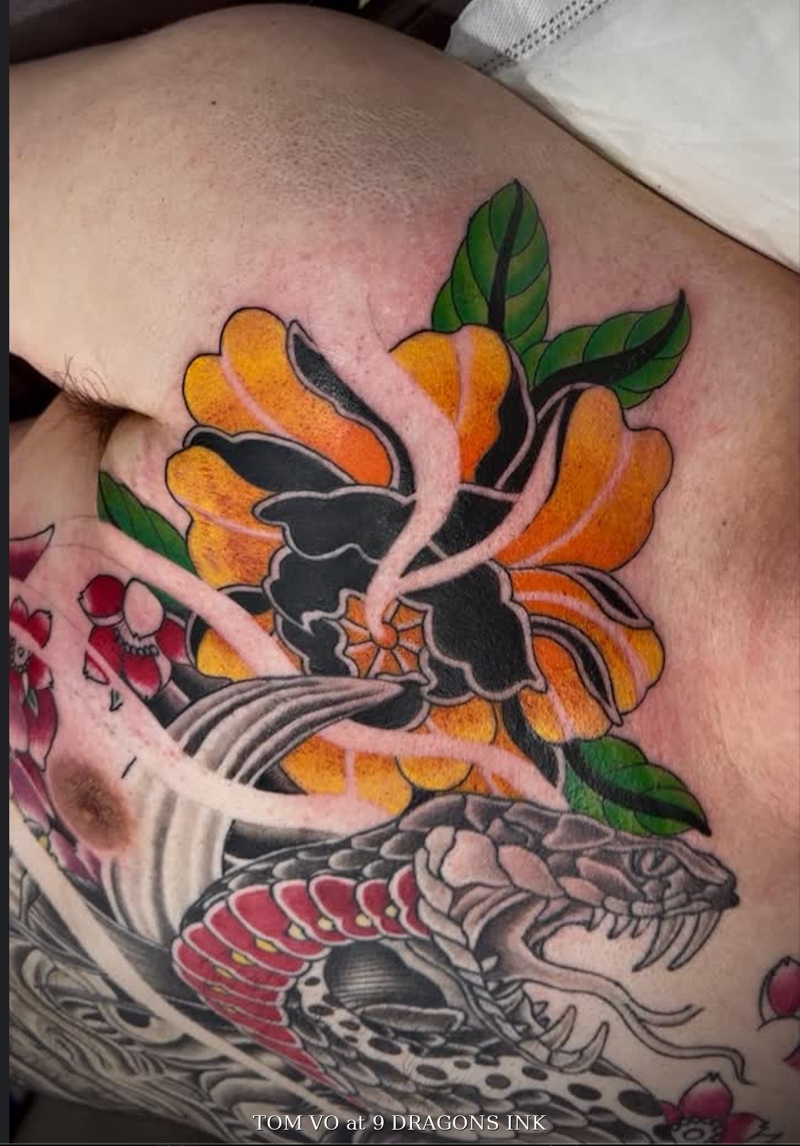 Snake and floral upper chest tattoo by Tom Vo at 9 Dragons Ink in San Jose