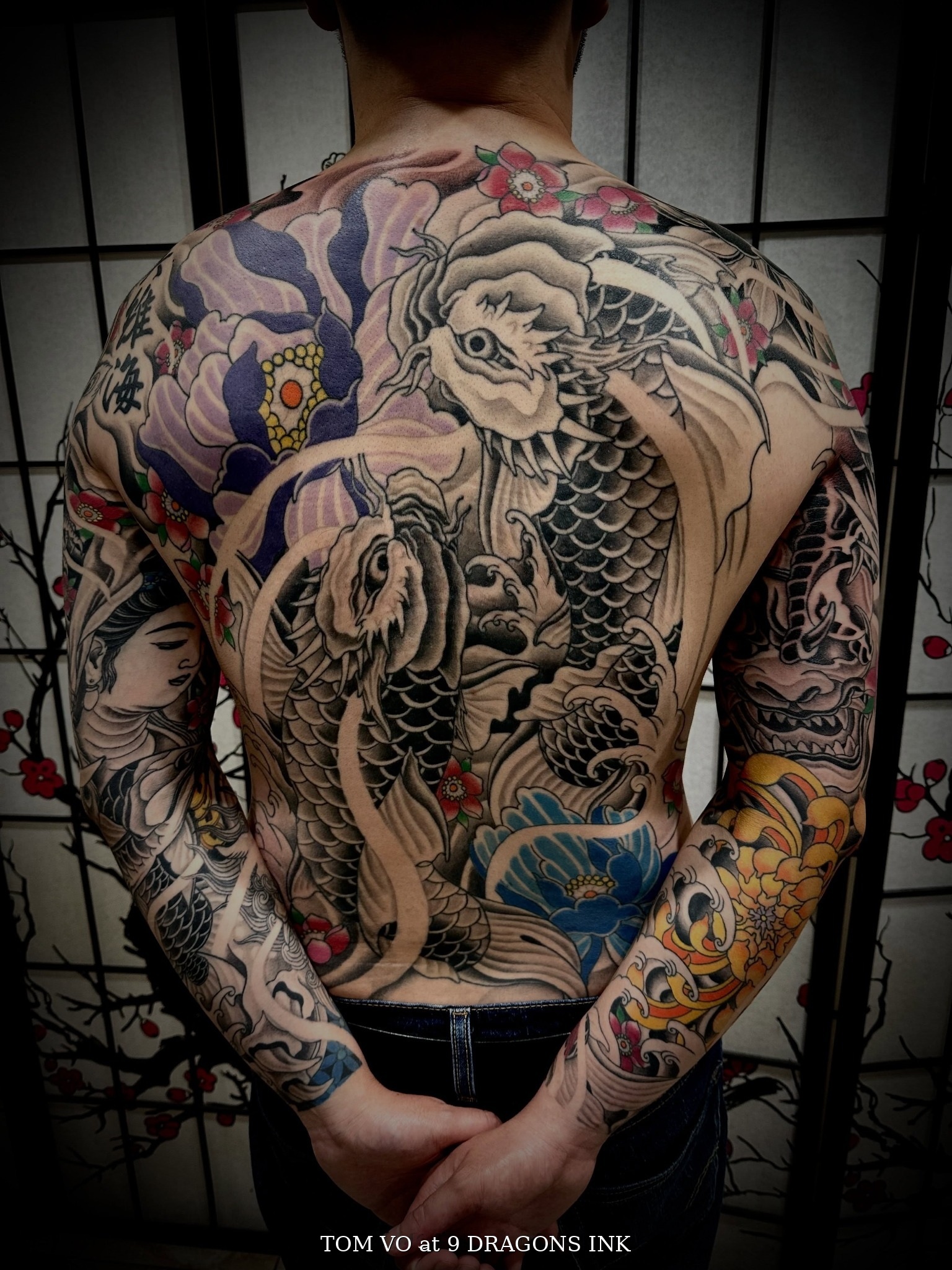 Full back tattoo with twin koi, Lady Buddha, Foo Dog and colorful florals by Tom at 9 Dragons Ink in San Jose